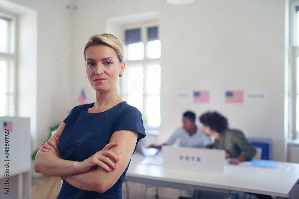Portrait of female voter filling election ballot paper. US citizen voting in polling place on election day, usa elections. Portrait of female voter filling election ballot paper. US citizen voting in polling place on election day, usa elections.
