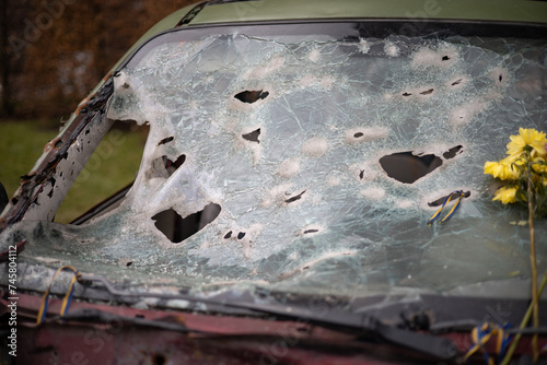 Holes on the windshield of the car, it was shot from a firearm. Bullet holes. Smash car windshield, broken and damaged car. The bullet made a cracked hole in the glass
