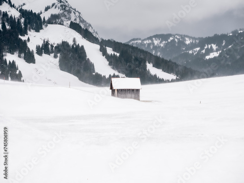 Wooden barn in the Alps during snowfall