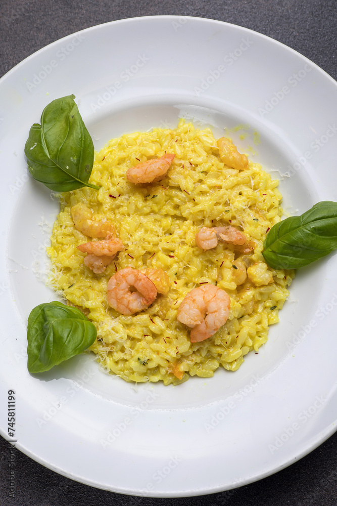 Risotto with shrimps and basil on a white plate