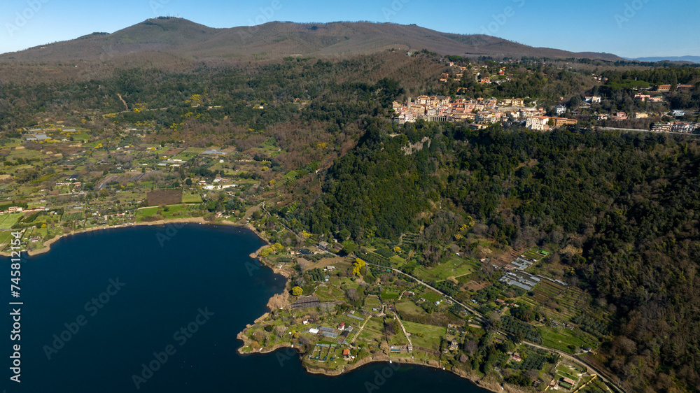 Aerial view of Nemi, a town of Castelli Romani regional park, in the Metropolitan City of Rome, Italy. The historic center is located in the Alban Hills overlooking Lake Nemi, a volcanic crater lake. 