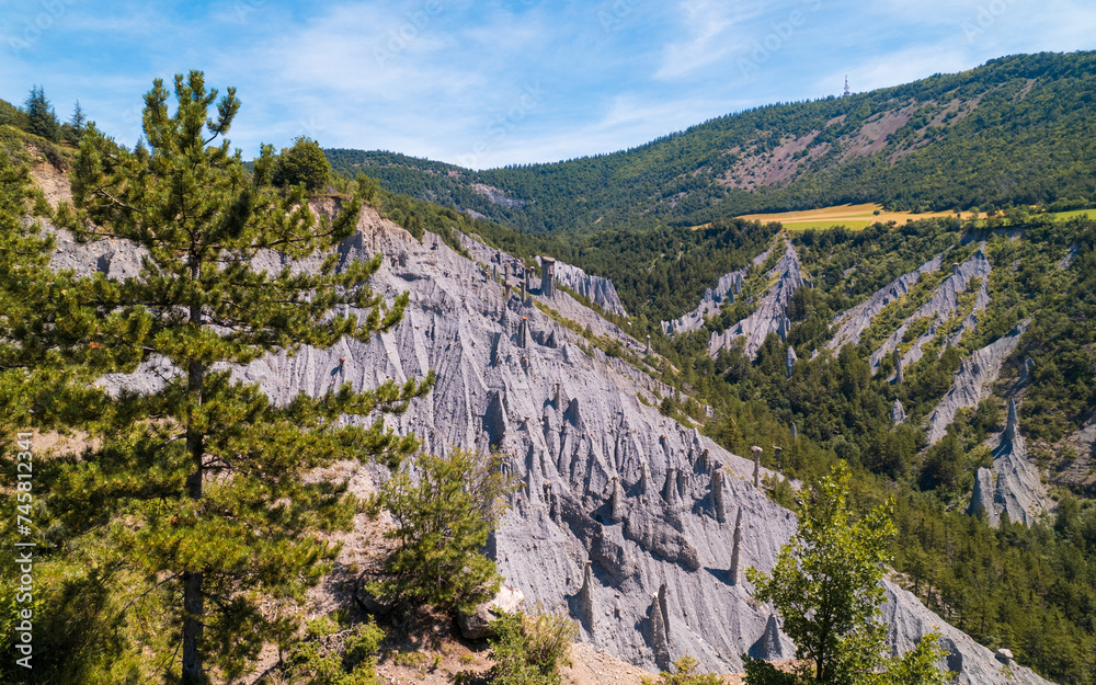 Aerial photography by drone of the rock formations, the Demoiselles Coiffées in Serre-Ponçon and its mountains, located in the Hautes-Alpes in France