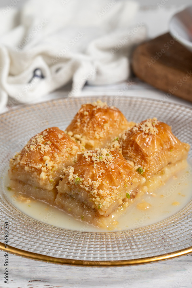 Baklava with milk. Milk baklava with hazelnuts on a white background. Local name sütlü nuriye baklava. Close up