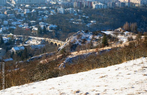 Viaduct in city district Hlubocepy and building, from snowy meadow, Prague. photo