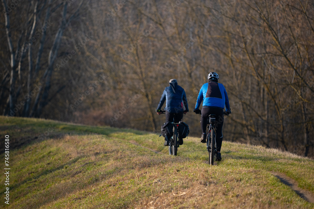 Fototapeta premium Cyclists on a mountain trail in the spring forest. Active lifestyle.