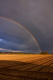 a double rainbow over an agricultural field