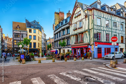 Cozy street with timber framing houses and tables of restaurant in Rouen, Normandy, France