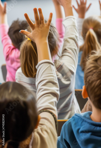 Children raising hands in classroom, eager to participate and learn.
