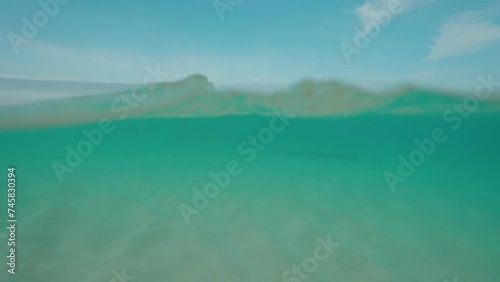 Clean ocean water and white sand beach close-up underwater dome split half half shot