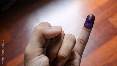 Inked pinky finger of a man's hand. Purple ink blots from voter's finger provides evidence of the presidential election (pilpres) and general election (pemilu) in Indonesia. photo