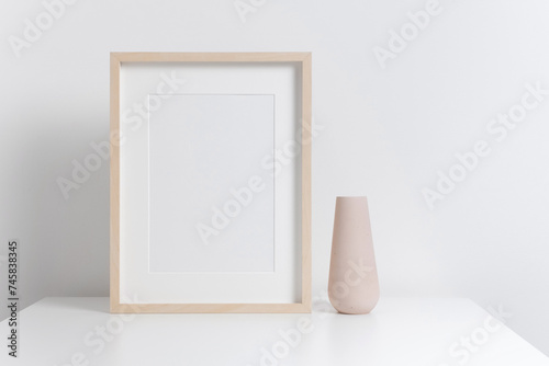 Fototapeta Naklejka Na Ścianę i Meble -  Blank wooden picture frame mockup with copy space in white minimalistic interior
