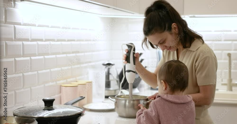 Loving mother and daughter using electric mixer for preparing dough Loving mother and daughter using electric mixer for preparing dough
