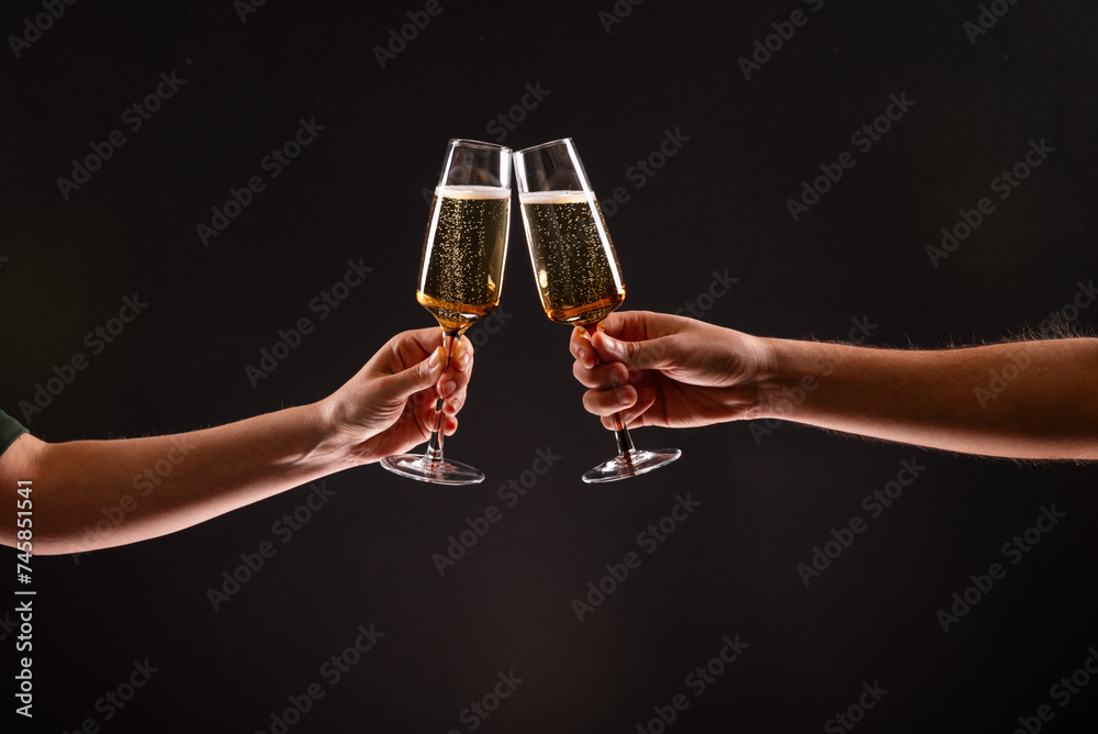 Two people clinking glasses of sparkling champagne or prosecco against ...