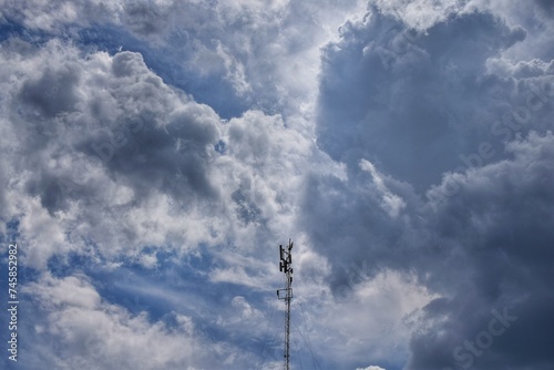 Cielo azul con antena centrada y con formación de nubes.