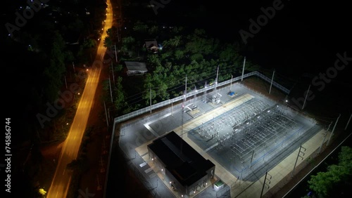 Time Lapse of An aerial view high voltage electric at night, Wide angle, high voltage substation with tall pylons and voltage distribution cables. Transformation station and electric power plant.