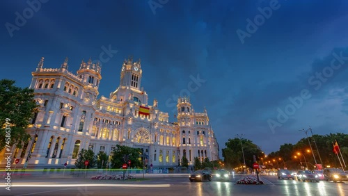 MADRID, SPAIN - FEBRUARY 19, 2024: Timelapse hyperlapse view of Cibeles palace and square, famous touristic landmark. Fountain on the square and traffic circle around. photo