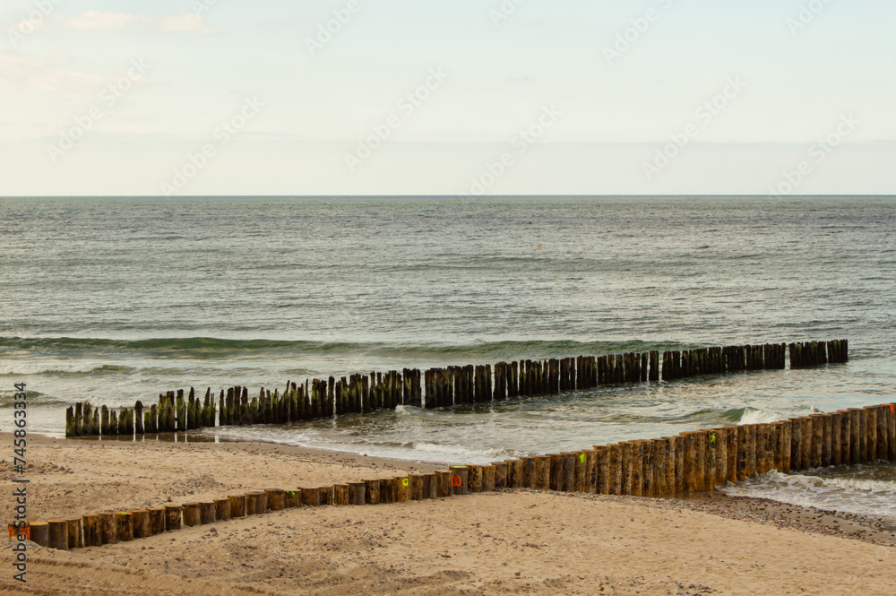 old broken wooden breakwaters compared to new fresh nice wooden breakwaters with sand