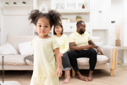 Happy African American family doing activities with daughter at home.