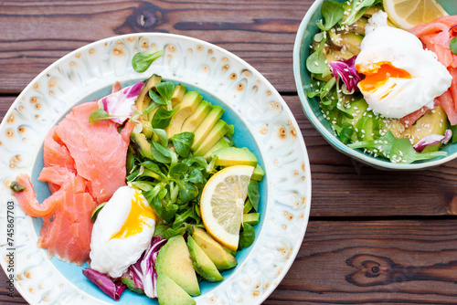Brunch with poached egg, avocado, arugula, flax seeds and salted salmon on a rustic wooden background. flatlay, horizontal. copy space