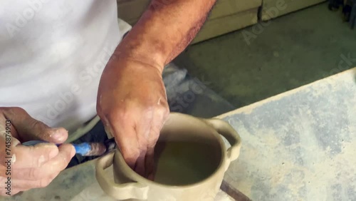 man's hands working with clay, making clay pots