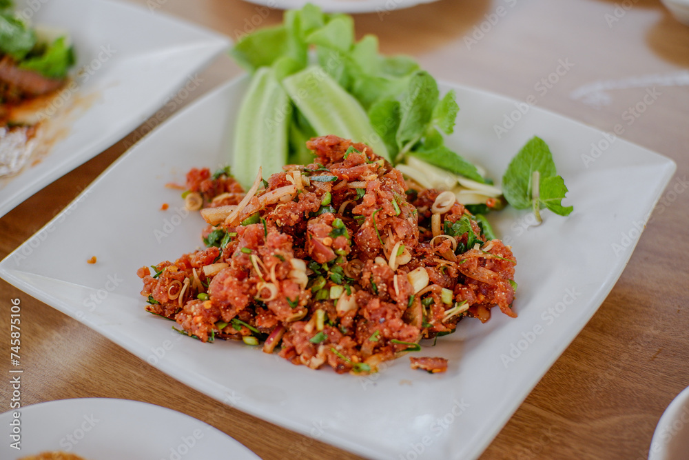 Raw meat beef cook, Spicy minced beef salad slice mixed with spices and herbs vegetable food of northeast Thailand style local. Raw meat beef cook, Spicy minced beef salad slice mixed with spices and herbs vegetable food of northeast Thailand style local.