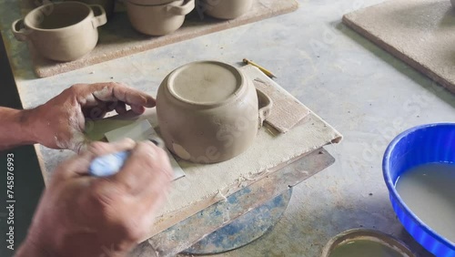 man's hands working with clay, making clay pots