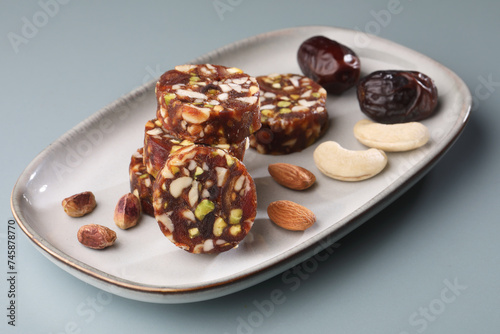 Healthy snacks, fitness lifestyle and high fiber diet concept with dates and dryfruits energy bars surrounded by dried fruits, Cashew Nuts, pistachios , almonds photo