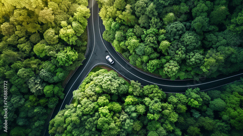 A road and your journey, Arial view of a lone vehicle on a winding rural forestry road as it approaches turns.