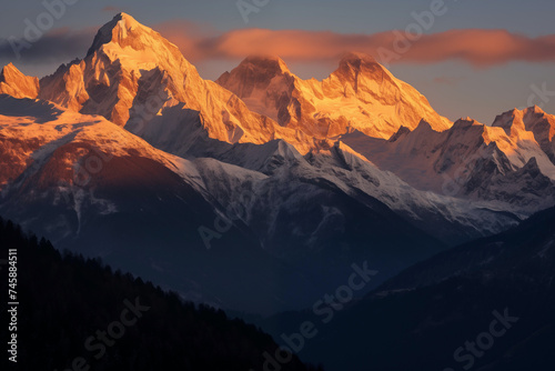 A high mountain range with the tips touching soft wispy clouds basking in golden hour sunlight