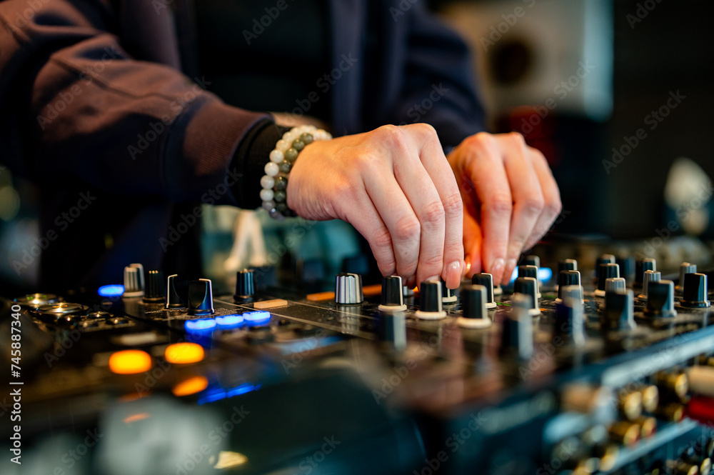 woman DJ Hands creating and regulating music on dj console mixer in concert woman DJ Hands creating and regulating music on dj console mixer in concert