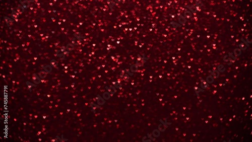 Vibrant crimson bokeh hearts create a textured background, perfect for themes of love, Valentine's Day, or romantic designs.