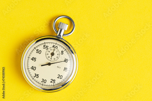 Mechanical stopwatch yellow background closeup. photo