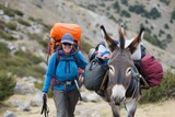  hiker with a donkey carrying camping gear 