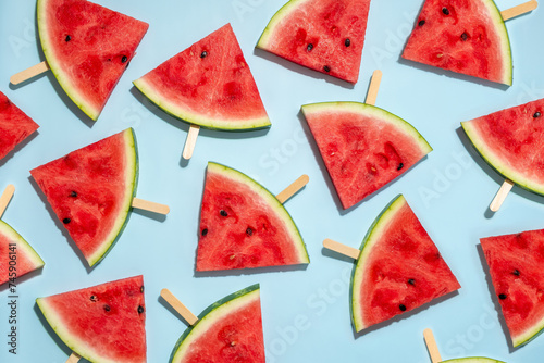 Fototapeta Naklejka Na Ścianę i Meble -  Watermelon slice popsicles on a blue background