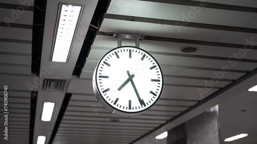 A classic round clock in airport or transportation building interior. Close-up and selective focus on the object. 