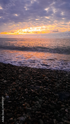 the sun dips below the horizon casting a warm golden glow across tranquil sea.