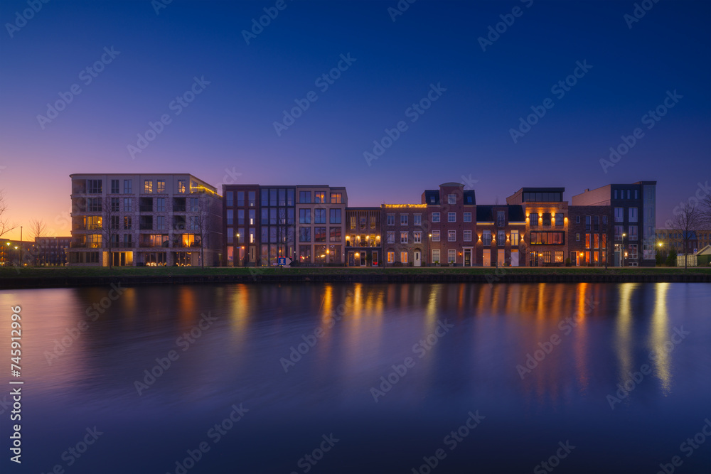 A cityscape during sunset. A apartment building near the water in the bay. Architecture. Travel photography.