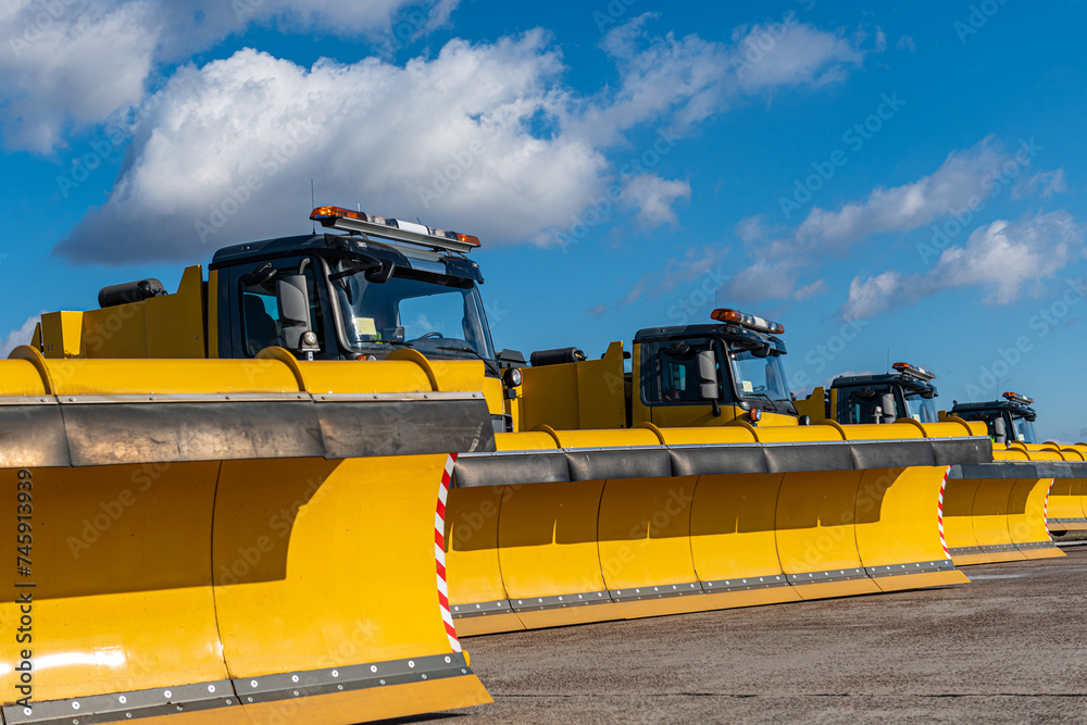 Snow removal vehicles in the airport. Snow plow trucks. Airport maintaining machinery. Training snow plow operators before winter.