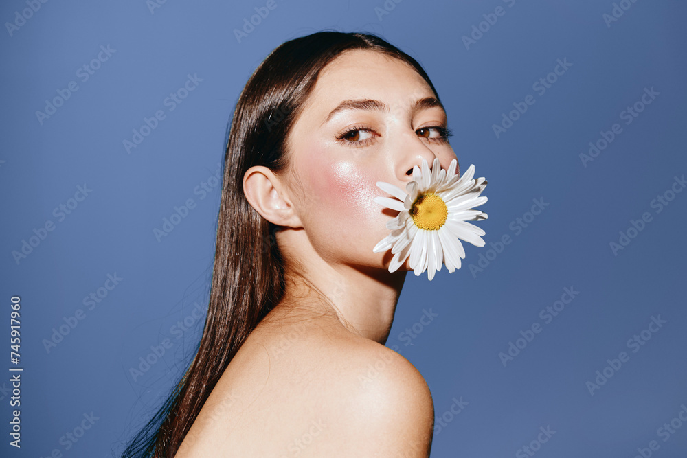 Floral Beauty: A Sensual Portrait of an Attractive Young Woman with a Fresh Flower in her Hair - obrazy, fototapety, plakaty 