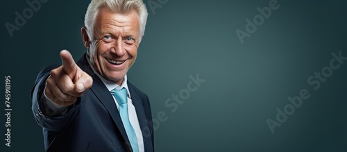Senior Businessman in a Suit Pointing Upwards with Confidence and Joy