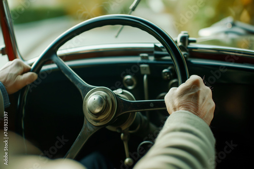 view over shoulder of a driver gripping a vintage steering wheel © Natalia