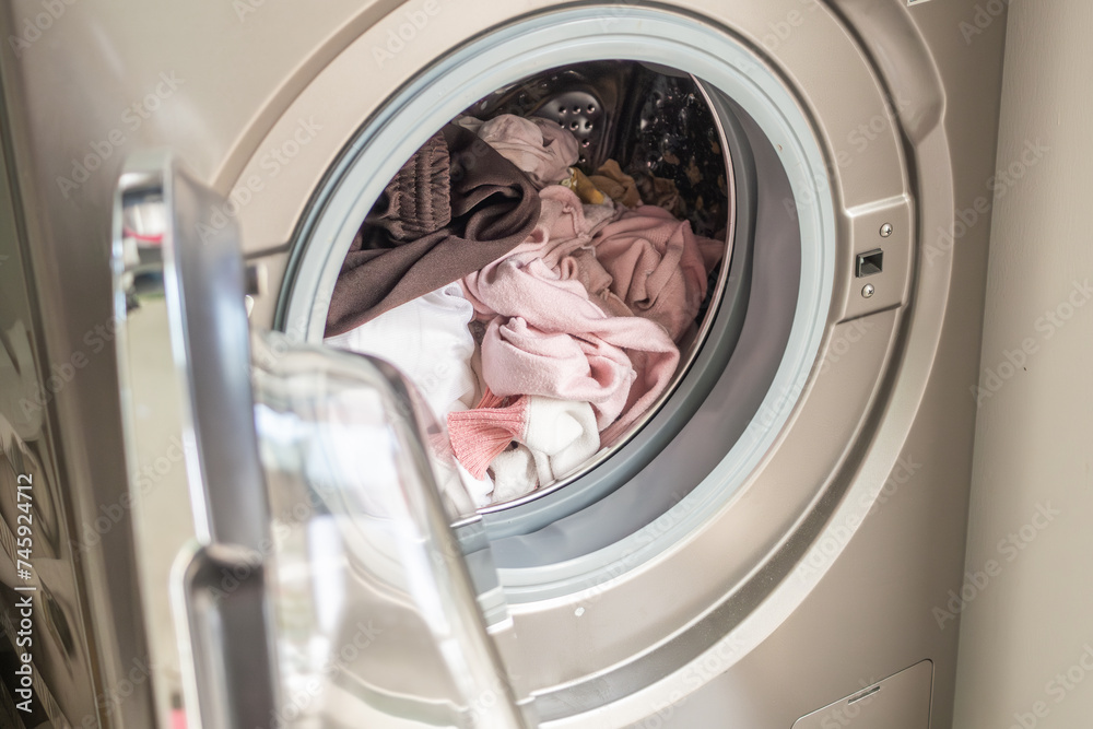 Washing machine loaded with clothes close up Washing machine loaded with clothes close up