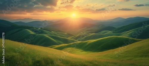 The sun setting over lush, undulating green hills, creating a peaceful and surreal landscape