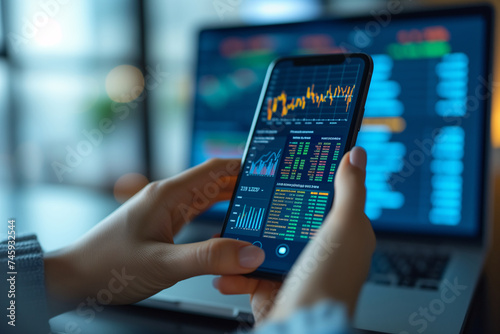 Wallpaper Mural Financial Professional Analyzing Data on Smartphone and Laptop in a modern office environment. Torontodigital.ca