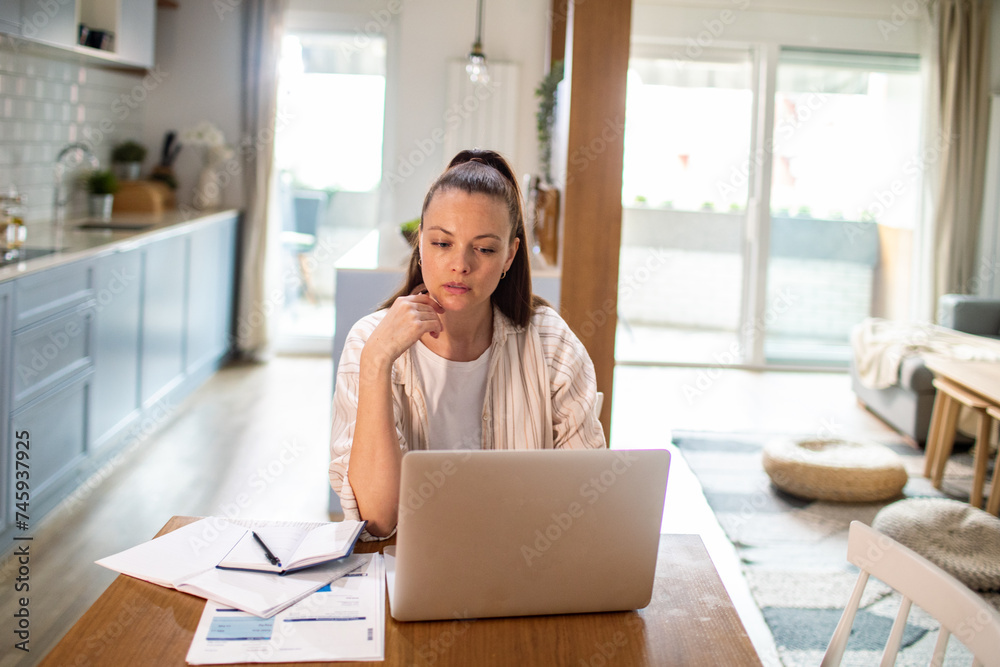 Stressed young woman working on laptop at home Stressed young woman working on laptop at home