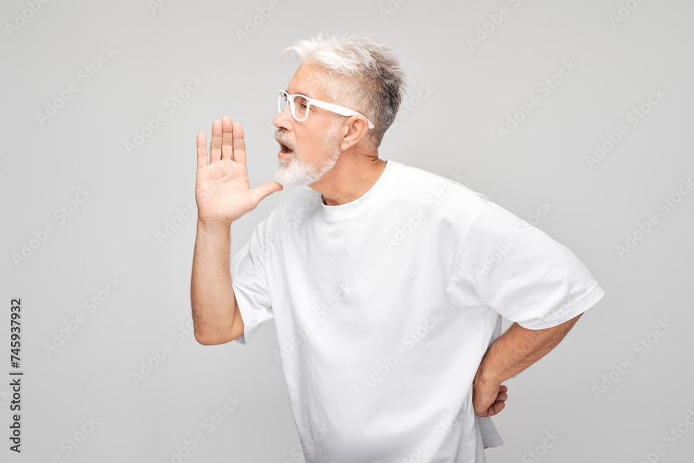 Portrait of senior man in white shouting loudly with hands, news, palms folded like megaphone isolated on white background Portrait of senior man in white shouting loudly with hands, news, palms folded like megaphone isolated on white background