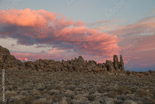 Dramatic and colorful clouds paint the sky over a unique rock feature.