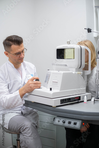 doctor and young patient in eye clinic, girl undergoing an eye test with professional optometrist using advanced diagnostic equipment, pediatric ophthalmology examination