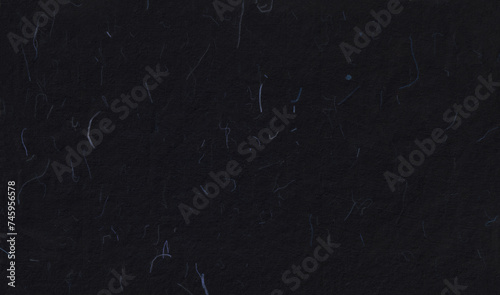 Hand made antique blank sheet black paper texture with blue fibers. photo