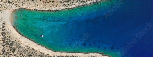 Aerial drone ultra wide photo from tropical exotic paradise secluded rocky island bay with deep turquoise sea forming a blue lagoon visited by yachts and sail boats in Caribbean exotic destination